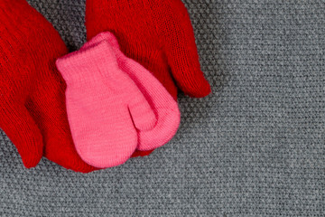 Baby pink mittens. The concept of family care and joy