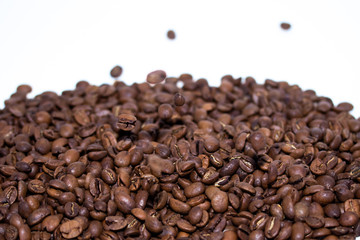 Roasted coffee beans pile and flying coffee beans isolated on white background. Selective focus.