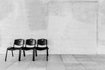 Black and white photo of chairs in corridor at school