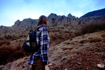 Tourist, traveler standing on background view mockup. Young woman with backpack traveling in the mountains