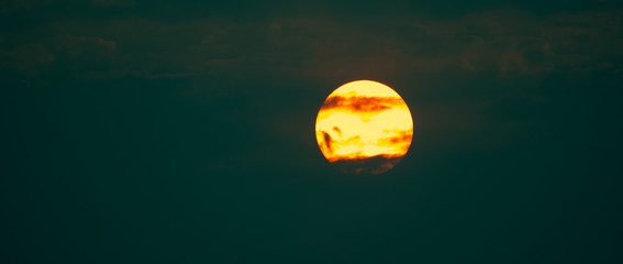 Big red sun and drark cloudns on summer season on sky and cloud