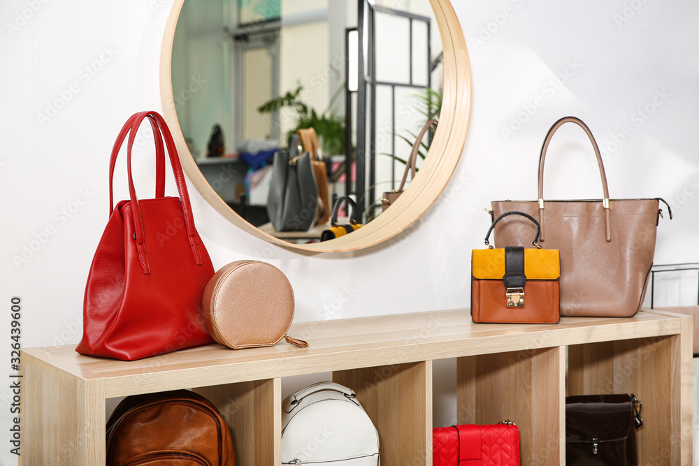 Wall mural Collection of stylish woman's bags on wooden shelving unit indoors