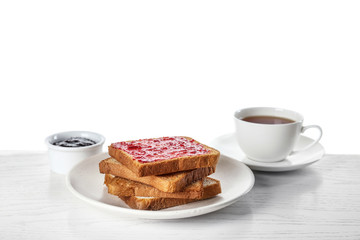 Toasts with jam and cup of tea on white wooden table