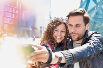 Portrait of young attractive man taking selfie with his girlfriend in the middle of the city