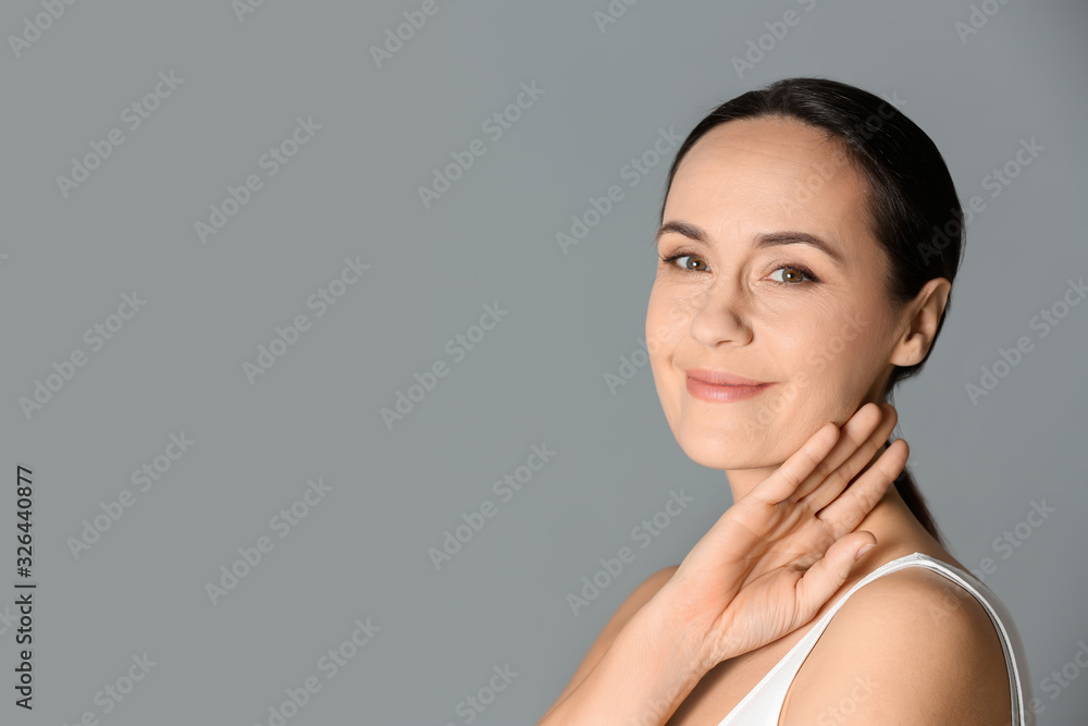 Canvas Prints Portrait of beautiful mature woman on grey background. Space for text