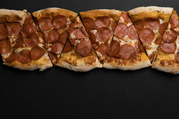 Food ingredients and spices for cooking mushrooms, tomatoes, cheese, onion, oil, pepper, salt, basil, olive and delicious italian pizza on black concrete background. Copyspace. Top view. Banner