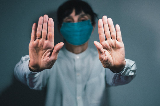 Stop coronavirus quarantine and Air pollution pm2.5 concept. Sick old woman wearing respirator mask for protect with outstretched arm. Wuhan, China epidemic virus symptoms background.