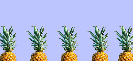 Many pineapples on a solid color background