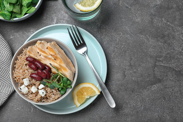 Tasty rice with beans served on grey table, flat lay. Space for text
