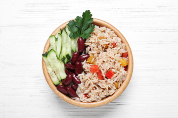 Delicious rice with beans on white wooden table, top view