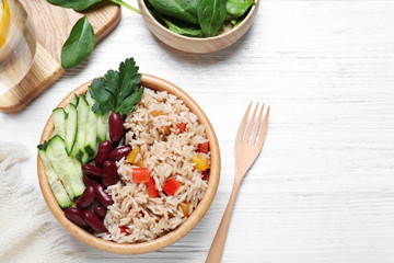 Delicious rice with beans served on white wooden table, flat lay