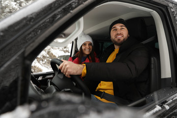 Young couple traveling by car, view through window. Winter vacation