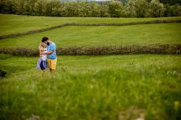 Loving couple enjoying a walk through grass land