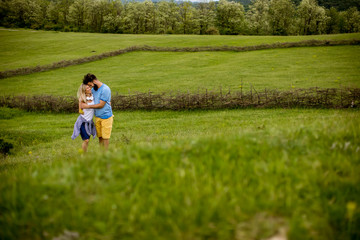 Fototapeta premium Loving couple enjoying a walk through grass land