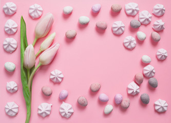 Fototapeta na wymiar Pink pastel Easter with delicate tulips, sweet meringues and sugar-coated chocolate eggs.