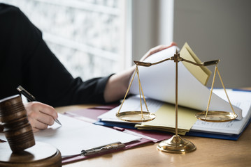 justice and law concept. Female judge in a courtroom on wooden table and Counselor or Male lawyer working in office. Legal law, advice and justice concept.