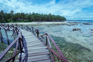 Beautiful landscape. Sunny day on seashore. Wooden bridge on Cloud 9 beach, Siargao Island Philippines.