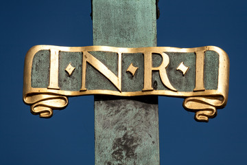 Sign I N R I (Iesus Nazarenus Rex Iudaeorum) on a religious sculpture on Charles Bridge in Prague,...