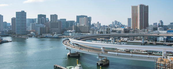 Yurikamome Train on Rainbow Bridge loop and Tokyo skyline　レインボーブリッジのループ橋を走るゆりかもめと東京湾岸のビル群