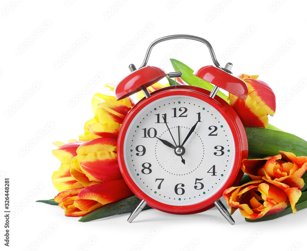 Poster red alarm clock and spring flowers on white background. time change