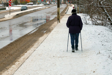 A woman in winter is engaged in wellness walking with sticks.