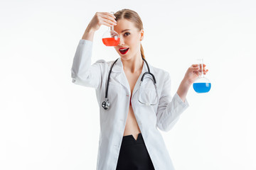 cheerful and sexy nurse holding flasks with red and blue liquid isolated on white