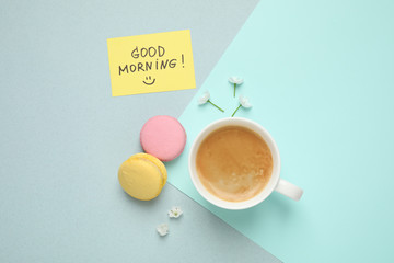 Obraz na płótnie Canvas Delicious coffee, macarons, flowers and card with GOOD MORNING wish on color background, flat lay