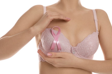 Woman with pink ribbon on white background, closeup. Breast cancer awareness