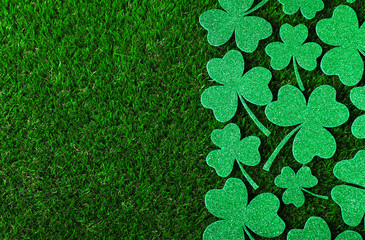 Flat lay composition with clover leaves on green grass, space for text. St. Patrick's Day...