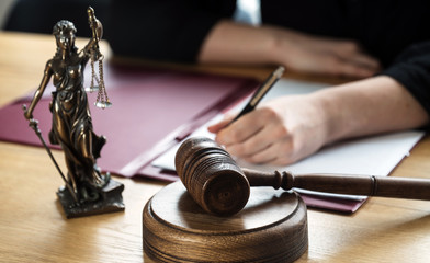 justice and law concept. Female judge in a courtroom on wooden table and Counselor or Male lawyer working in office. Legal law, advice and justice concept.