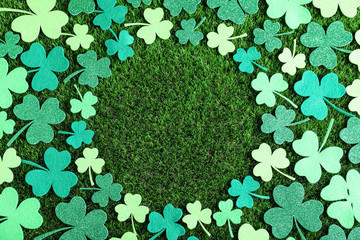 Frame made of clover leaves on green grass, flat lay with space for text. St. Patrick's Day...