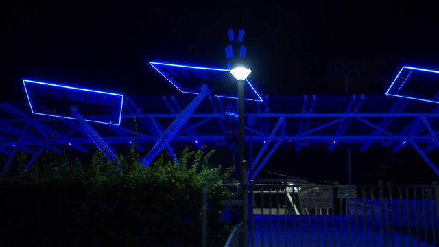 Night motion footage FPL solar power trees Downtown glowing neon blue