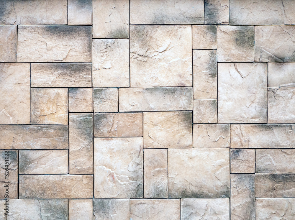 Aufkleber the beige-gray wall is lined with rectangular blocks of different sizes. stones with a rough surface