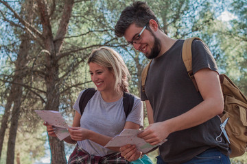 Young couple in the countryside looking at a map while smiling