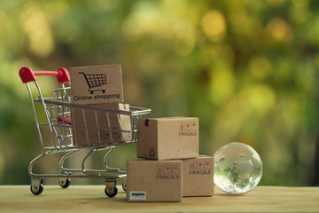 Shopping Online and e-commerce concept: Paper boxes in shopping cart and crystal globe. Trading...