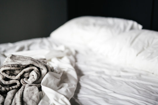 Soft gray blanket on white sheets