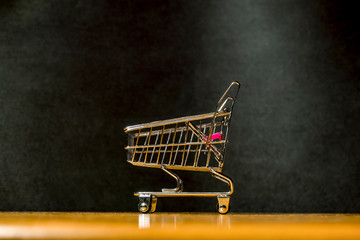  grocery cart on a wooden surface on a dark background