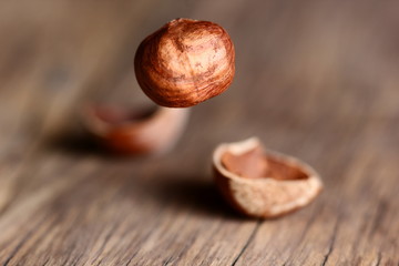 tossed hazelnuts falling on a wooden table