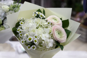 white bouquet on the store counter. Chrysanthemums and roses
