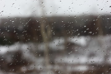raindrops on the window on a blurred background of inclement weather