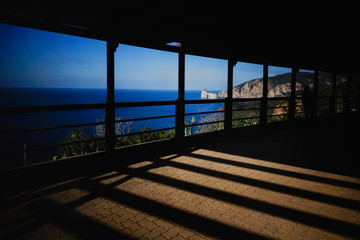 Panoramic view of sea and coast line from an outdoor terrace with high contrast light and shadows patterns.