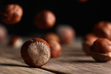 tossed hazelnuts falling on a wooden table