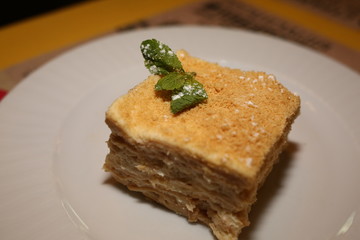 a piece of cake Napoleon lies on a plate in a restaurant, close-up