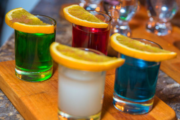 4 colored cocktails with oranges