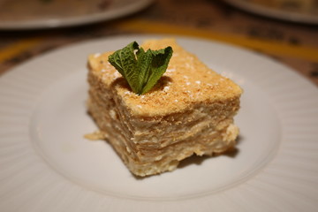 a piece of cake Napoleon lies on a plate in a restaurant, close-up