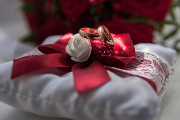 wedding rings on a red bow