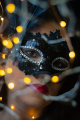 mujer con mascara de carnaval veneciana con luzes amarillas y azules 