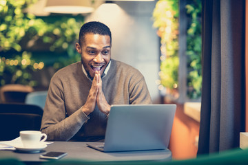 Excited black manager looking at laptop and screaming