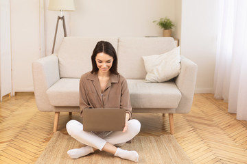 Young woman working at home on the floor
