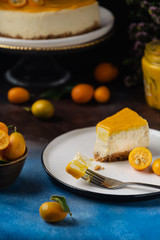 Piece of citrus curd cheesecake cake with kumquats